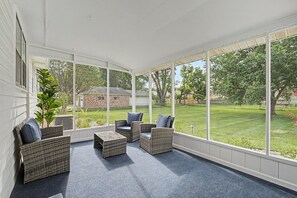 A covered patio with wicker furniture and a view of a grassy yard. - Remodeled home by Air Force Base, Wright State University and Nutter Center (Fairborn)