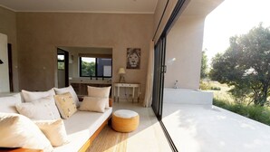 Un interno moderno con un divano, un poggiapiedi e vista sull'esterno.