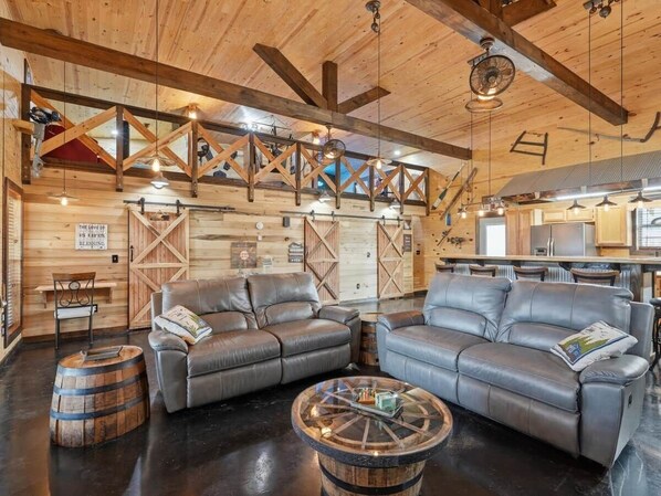 A cozy interior with wooden beams, a leather sofa, and a rustic coffee table.