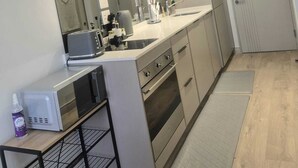 Eine kleine Küche mit modernen Geräten, einer Mikrowelle, einem Toaster und einem Spülbecken.