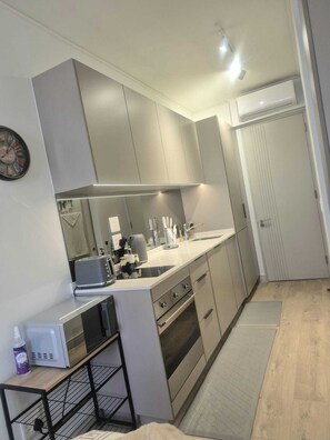 A compact kitchen with modern appliances, a microwave, a toaster, and a sink. - Charming Studio in beautiful Johannesburg, perfect for your stay. (Johannesburg)