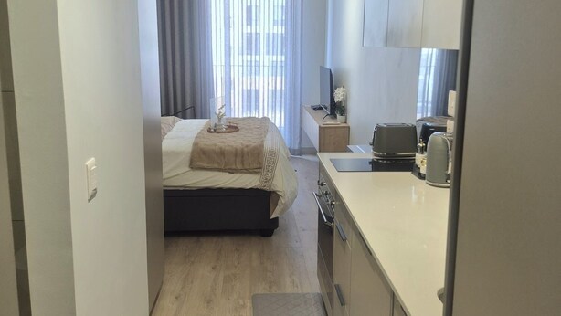 Ein kleines Hotelzimmer mit Bett, einer Küchenzeile und einem Badezimmer.