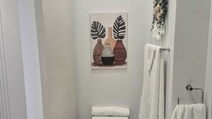 Ein modernes Badezimmer mit Toilette, Waschbecken und dekorativen Wandbildern.