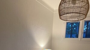 A room with a wooden bench, a wall-mounted lamp, and a window with a view of trees. - Luxury 8-person villa on the Côte d'Azur with a pool and ocean views from every room (Fréjus)