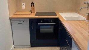 A compact kitchen with a dishwasher, oven, and a window above the sink. - Luxury 8-person villa on the Côte d'Azur with a pool and ocean views from every room (Fréjus)
