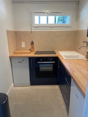 A compact kitchen with a dishwasher, oven, and a window above the sink. - Luxury 8-person villa on the Côte d'Azur with a pool and ocean views from every room (Fréjus)