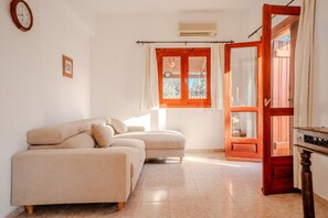 A room with a sofa, a wooden door, and a window with curtains. - Villa Oleander- with Private pool & Near the beach (Chania)