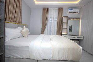 Habitación de hotel moderna con una cama grande, una mesita de noche, un espejo y un equipo de aire acondicionado.