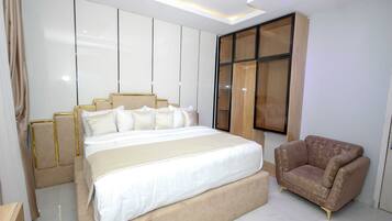 Un dormitorio con una cama grande, un sofá y un armario.