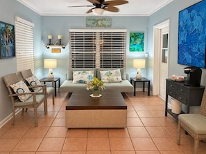 A living room with a sofa, two chairs, a coffee table, and a ceiling fan. - 5-bedroom beach house with pool - 2 blocks from beach, 1 hr from Disney (Satellite Beach)