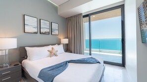A hotel room with a bed, a starfish decoration, a view of the sea, and a balcony with a glass door. - 3-bedroom luxury beachfront condo - Encantame Soleil with lazy river, waterslide (Puerto Penasco, Son)