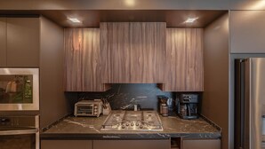 A modern kitchen with built-in appliances, a marble countertop, and wooden cabinetry. - 3-bedroom luxury beachfront condo - Encantame Soleil with lazy river, waterslide (Puerto Penasco, Son)