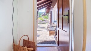A wooden door leading to an outdoor area with a bench and a basket. - Černý Důl by Interhome (Cerny Dul)