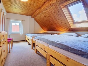 A room with two wooden beds, a window, and a radiator. - Černý Důl by Interhome (Cerny Dul)