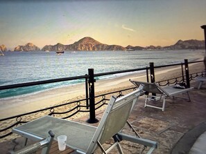 Zona d'seure al costat de la platja amb vista a l'oceà i a les muntanyes llunyanes.