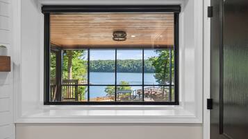 A window with a view of a lake and a deck area.