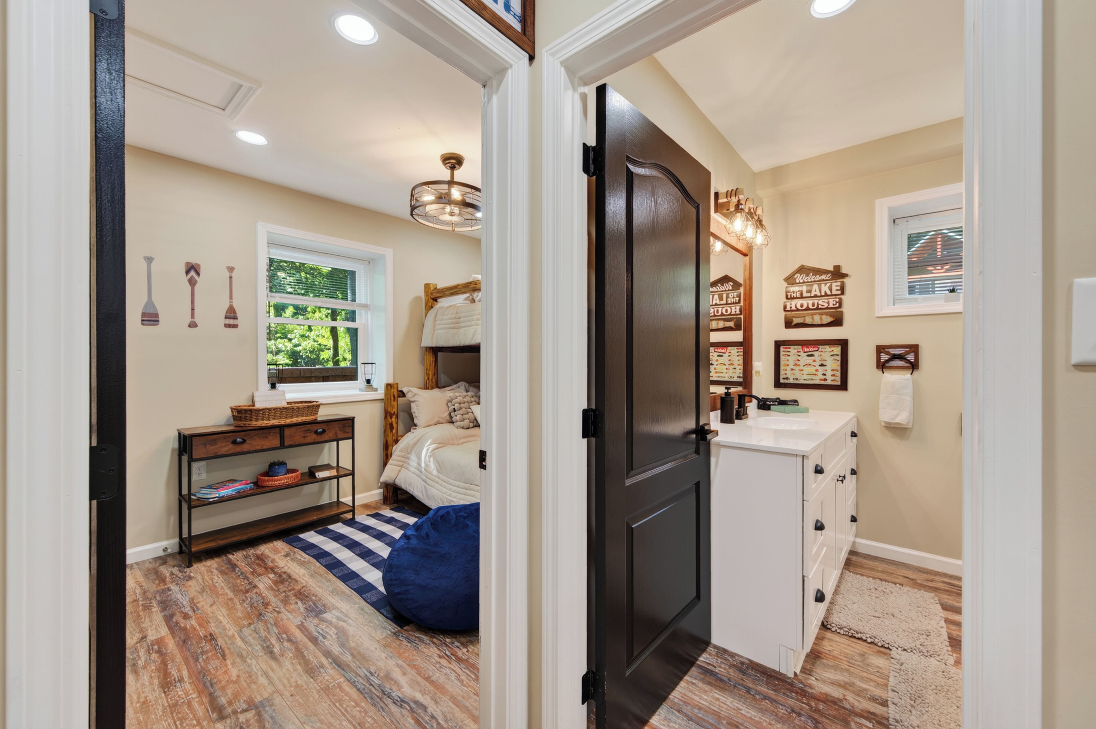 A bedroom with a bed, a nightstand, a dresser, a window, and a door.