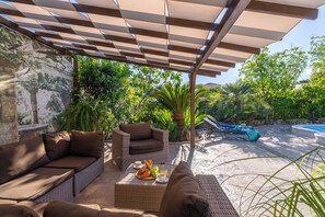 Un espace extérieur aménagé avec des meubles en osier et une table dressée avec de la nourriture et des boissons.