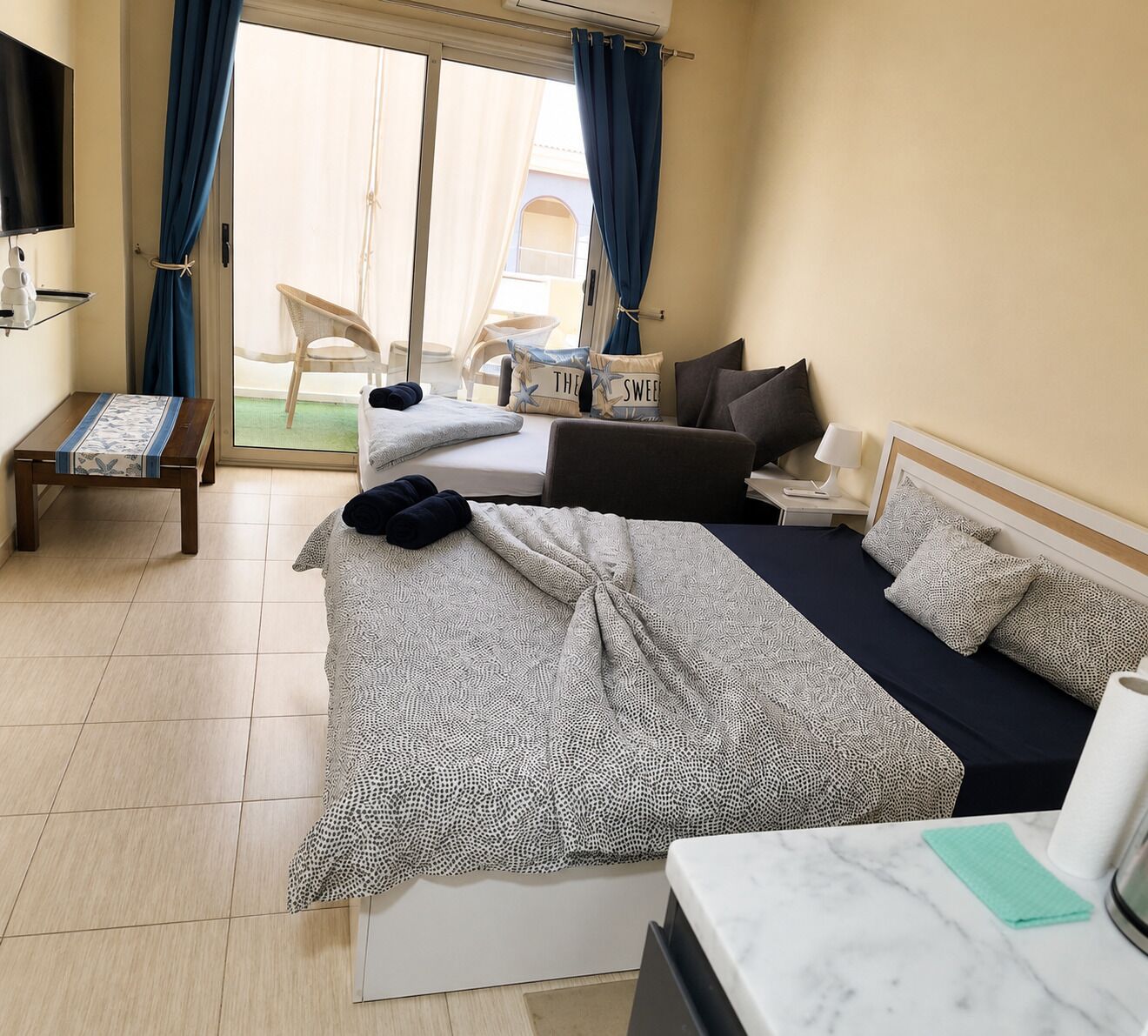 Ein Hotelzimmer mit Bett, Schreibtisch, Stuhl und Fernseher.
