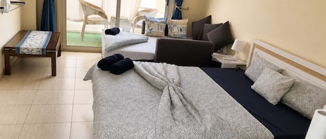 A hotel room with a bed, a desk, a chair, and a television.