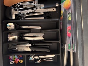 A set of kitchen utensils including whisks, spoons, and forks, neatly arranged in a compartmentalized case. - Klara Florenza (Hurghada)