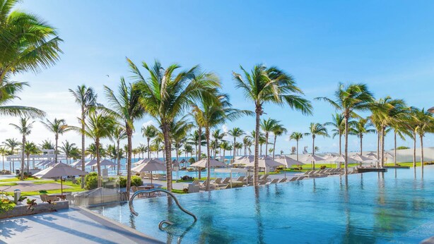A resort pool area with palm trees, lounge chairs, and umbrellas. - 5-Star Luxury Resort with Oceanfront Suite @ Garza Blanca [Dec 26 - Jan 2] (Cancun)