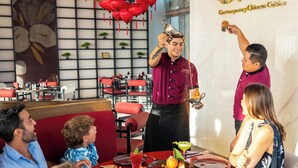 A restaurant interior with a dining table, chairs, and a waiter serving food. - 5-Star Luxury Resort with Oceanfront Suite @ Garza Blanca [Dec 26 - Jan 2] (Cancun)