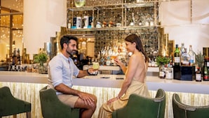 A bar area with a counter, seating, and a decorative wall with bottles. - 5-Star Luxury Resort with Oceanfront Suite @ Garza Blanca [Dec 26 - Jan 2] (Cancun)
