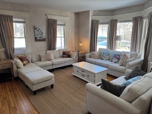 Ein geräumiges Wohnzimmer mit zwei Sofas, einem Couchtisch und einer Lampe.