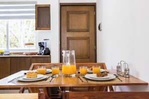 A breakfast table set with plates of food, glasses of orange juice, and a pitcher of juice. - Nature, Tranquility, and the Beach (Tulum)