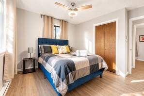 A bedroom with a bed, bedside tables, a ceiling fan, and a wardrobe. - Pocono Pines Retreat Hot Tub & Cozy Escape in PCP (Tobyhanna)