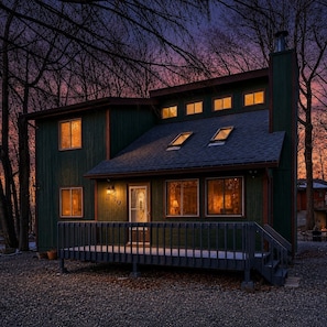 A two-story house with a porch, multiple windows, and a chimney. - Pocono Pines Retreat Hot Tub & Cozy Escape in PCP (Tobyhanna)