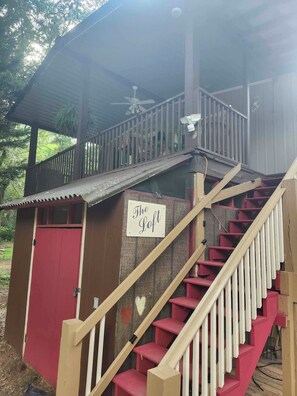 Una escalera de madera conduce a un espacio cubierto con un cartel que dice 'The Loft'.