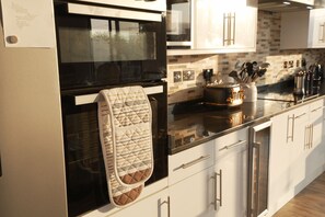 A kitchen with a microwave, oven, and a hanging towel. - Luxury 3 Bedrooms 4 Bathrooms Penthouse Roof Terrace With Parking (London)