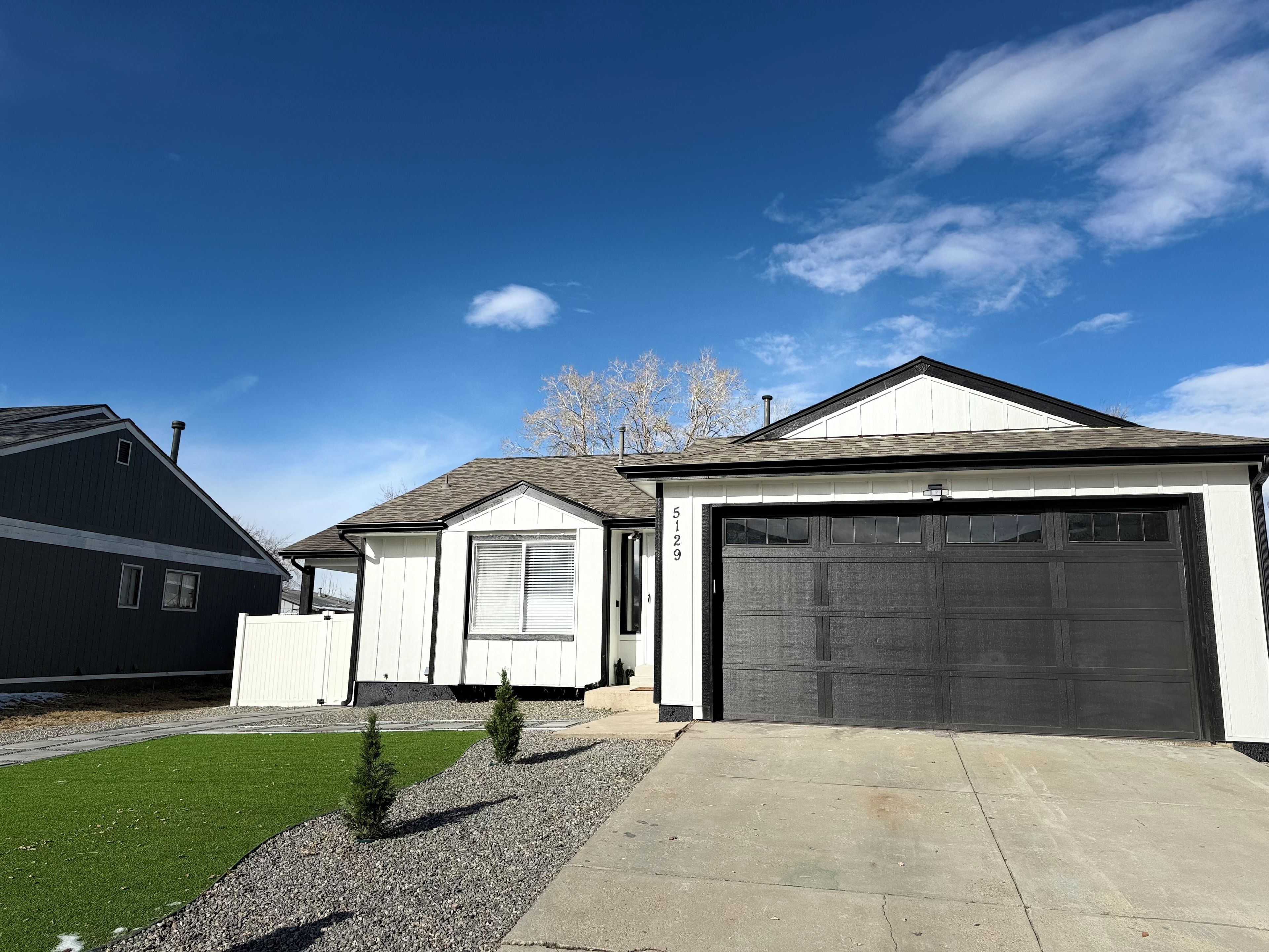 A residential property with a garage, a driveway, and a well-maintained lawn.