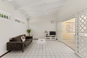 A modern living room with a brown sofa, a white coffee table, and a TV on a white stand. - Villa Cuartillo | Spacious 8-person villa with a private pool (Willemstad)