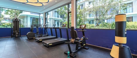 A gym with treadmills, weight machines, and a punching bag.