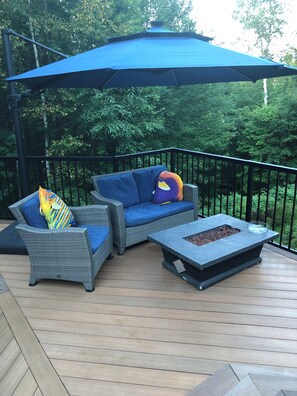 An outdoor deck with wicker furniture, a blue umbrella, and a fire feature. - Mont-Tremblant Escape:Cozy Fireplace & Hot Tub
Entire Home
Sleeps 6
Pet Friendly (Mont-Tremblant)
