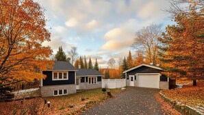 A two-story house with a driveway and a garage. - Mont-Tremblant Escape:Cozy Fireplace & Hot Tub
Entire Home
Sleeps 6
Pet Friendly (Mont-Tremblant)