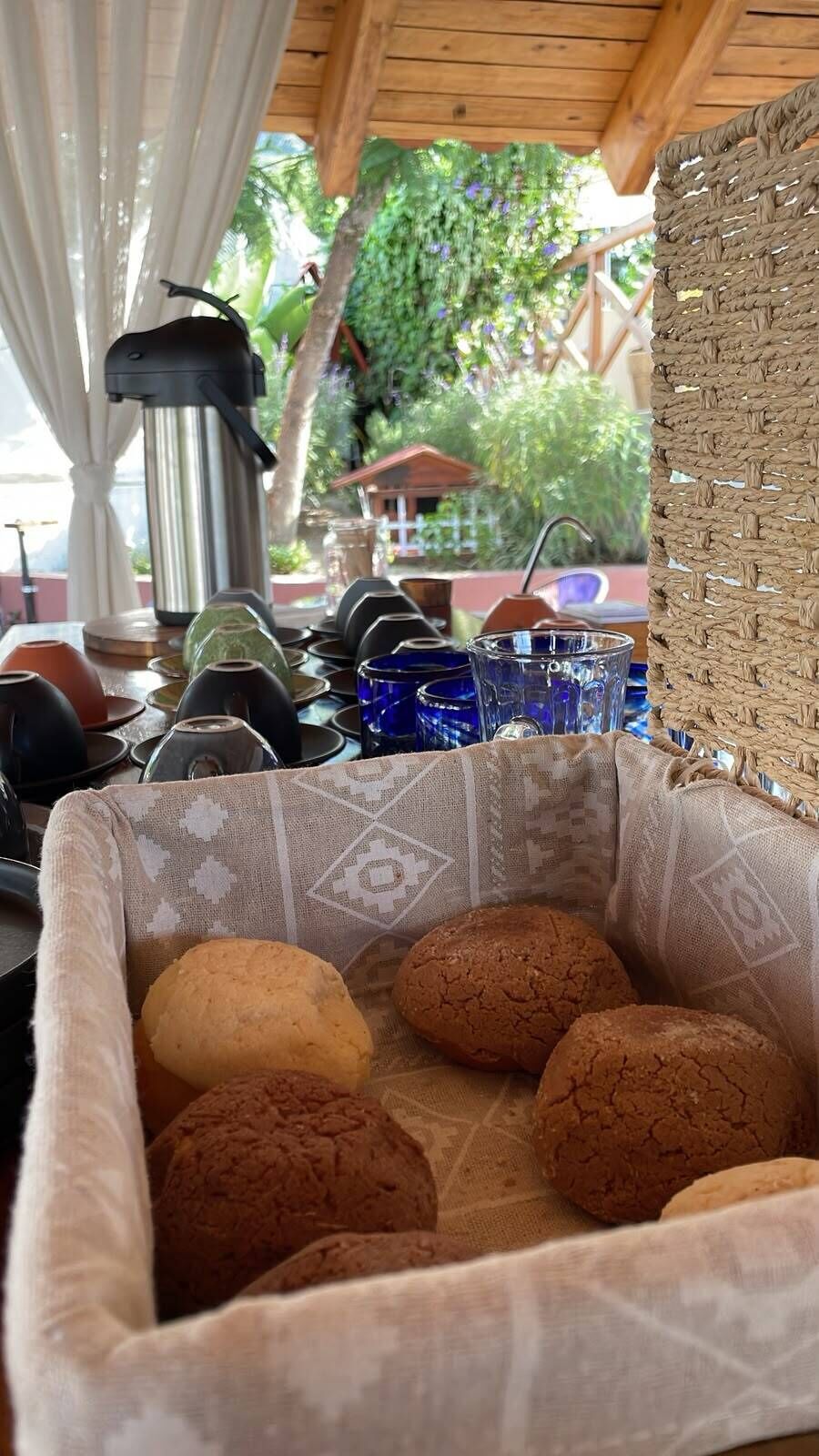 Una zona de cocina con una cesta tejida que contiene galletas, una cafetera y varios utensilios de cocina.