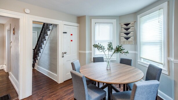 A dining area with a round table, four chairs, and a vase with greenery. - Downtown Rochester Home / 3 Bedrooms, Parking (Rochester)