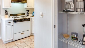 A kitchen with white cabinets, a stove, and a coffee maker on a shelf. - Downtown Rochester Home / 3 Bedrooms, Parking (Rochester)