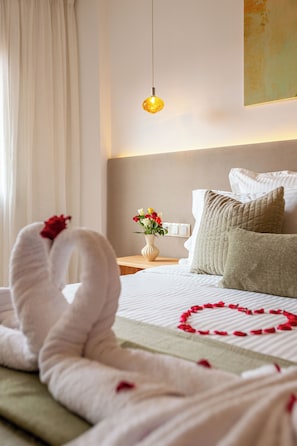 A hotel room with a bed, pillows, a vase with flowers, and a wall-mounted light fixture. - Cosy 1BR Apartment in Guéliz, Free Parking, Near Carré Eden Mall (Marrakesh)