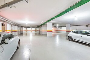 A clean, well-lit parking garage with white walls and a polished floor. - Cosy 1BR Apartment in Guéliz, Free Parking, Near Carré Eden Mall (Marrakesh)