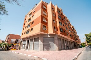 A multi-story building with balconies, air conditioning units, and a pedestrian walkway. - Cosy 1BR Apartment in Guéliz, Free Parking, Near Carré Eden Mall (Marrakesh)