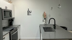 Een moderne keuken met een magnetron, oven en een spoelbak met kraan.