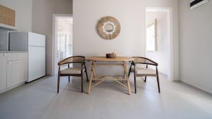 Una cocina moderna con una mesa de comedor y sillas, un espejo decorativo en la pared, y vistas al exterior.