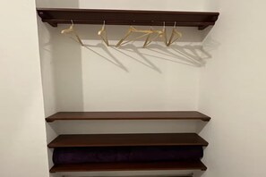 A wall-mounted wooden shelf with three levels, one of which has a purple cushion. - Downtown Apartment (Puerto Ayora)