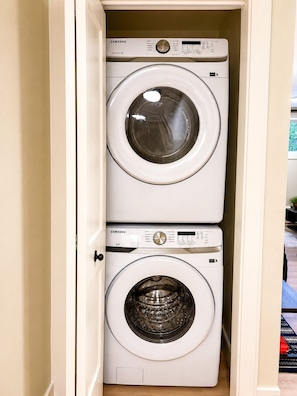 A Samsung front-loading washer and dryer stacked in a cabinet.