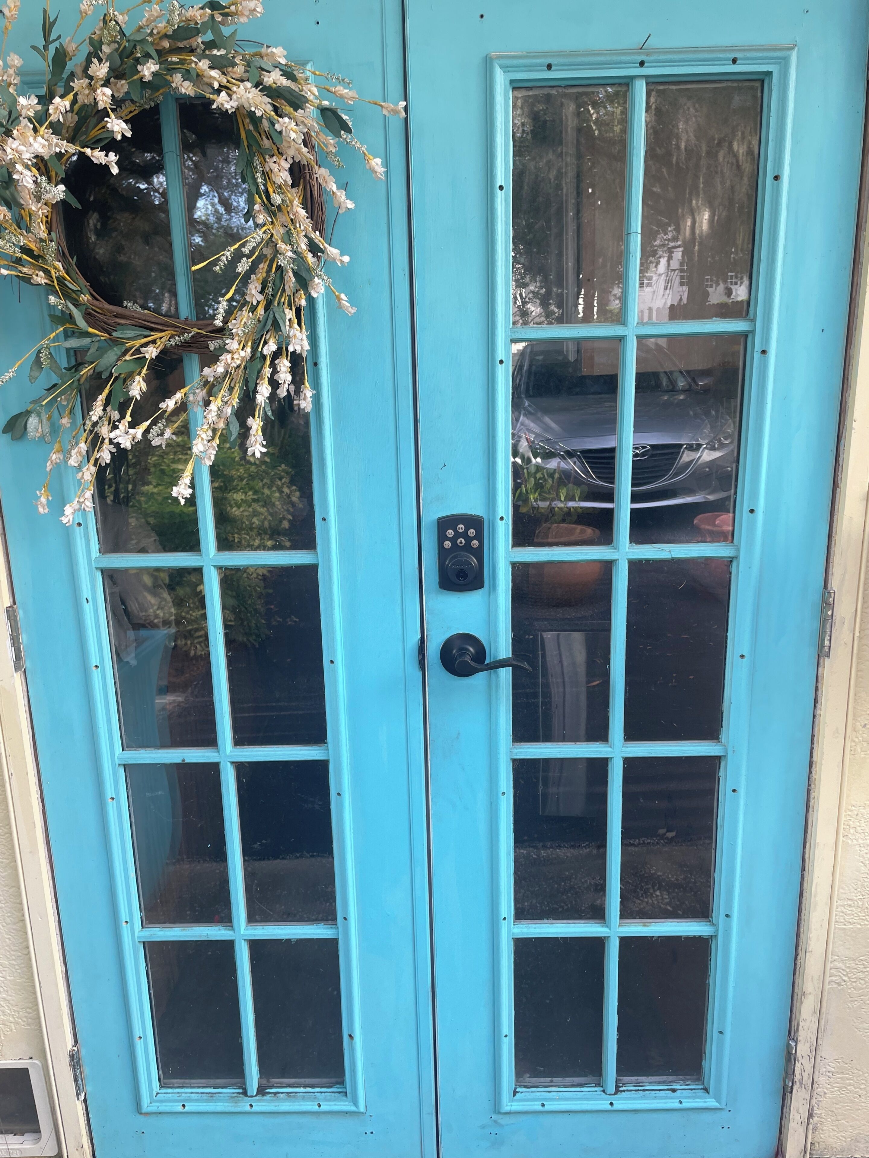 A turquoise double door with a keyhole and a lock.